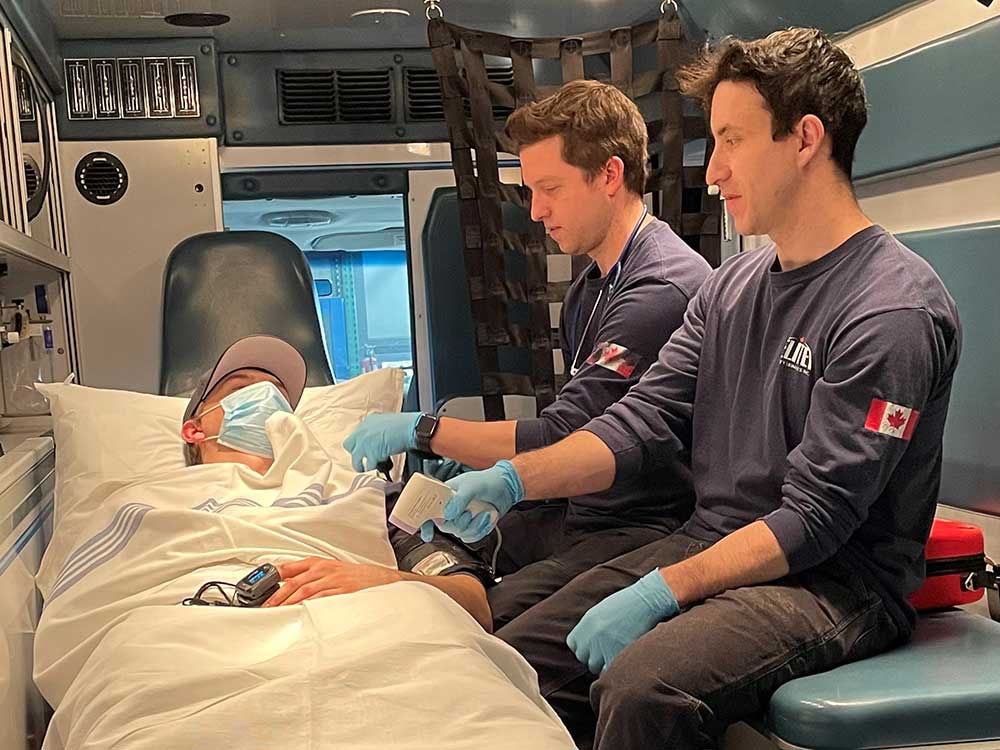Emergency medical responders (EMRs) with patient in ambulance